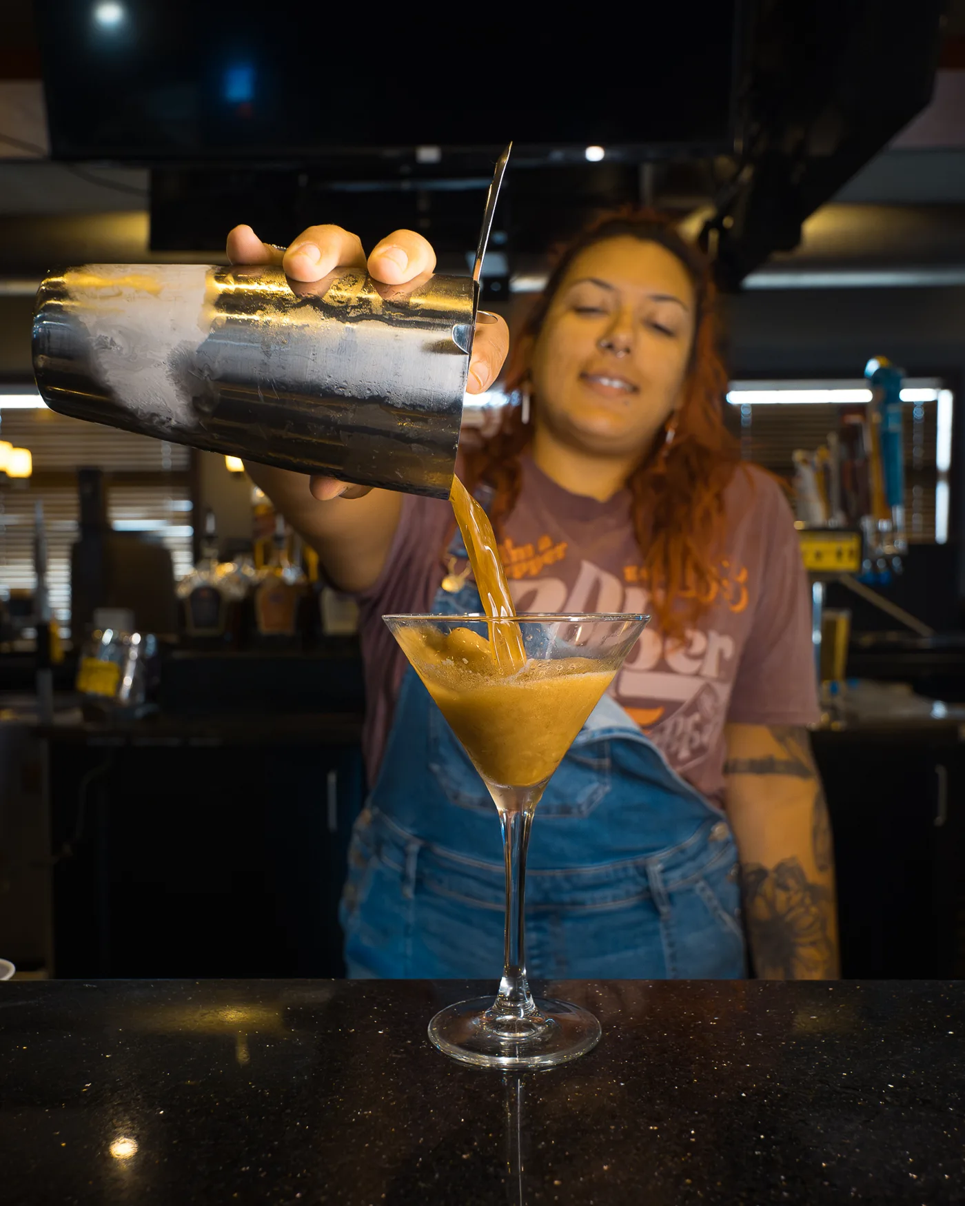 Your bartender pouring a fresh shaken cocktail at 212 Your bartender pouring a fresh shaken cocktail at 212