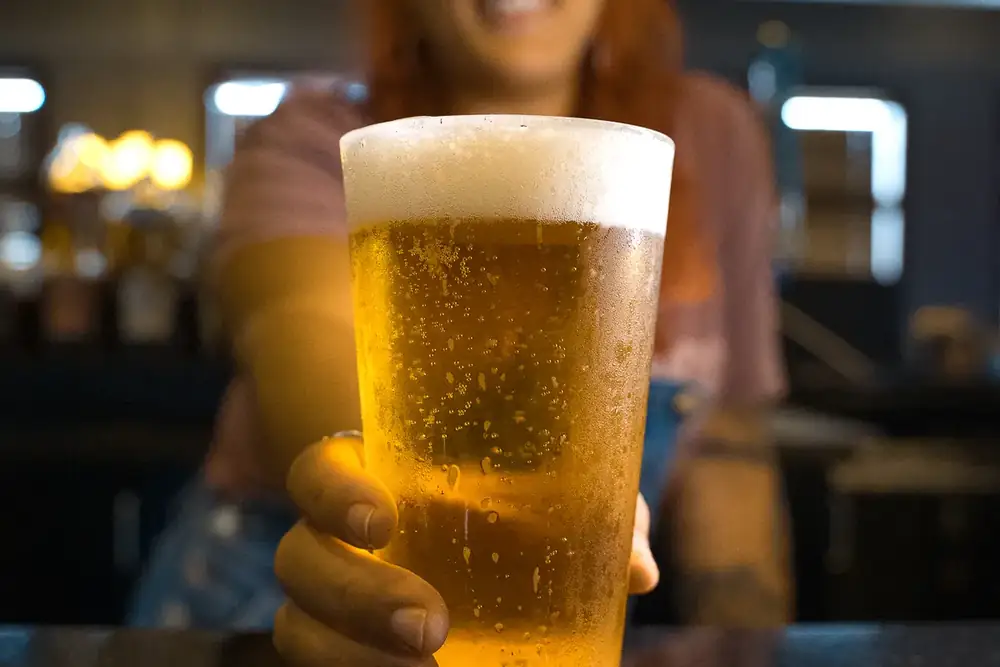 Your bartender handing over a cold draft beer at 212