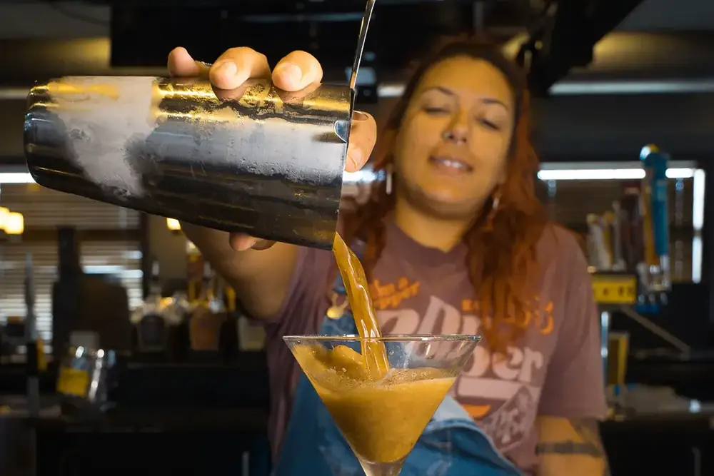 Your bartender pouring a fresh shaken cocktail at 212