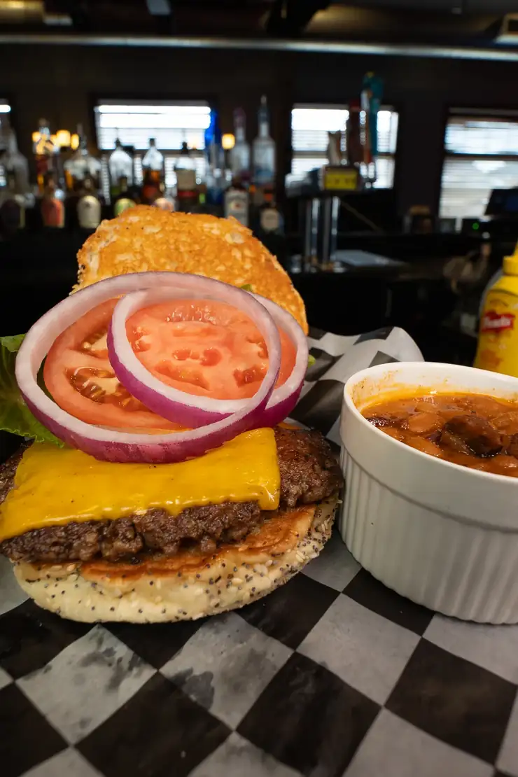 A Classic burger with American cheese, tomato and red onion, with baked beans