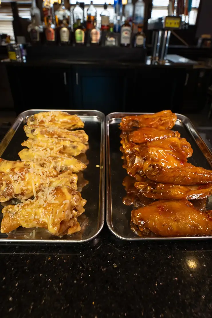 Two trays of house smoked wings, one garlic parmesan and one buffalo