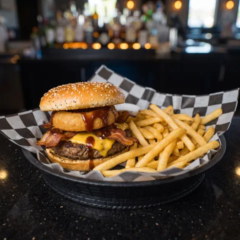 Barber Burger at 212 The Boiling Point: Seasoned patty topped with American cheese, hickory bacon, an onion ring and drizzled with BBQ sauce