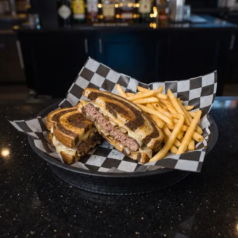 The Patty Melt on toasted marbled rye with sauteed onions and melted Swiss and American cheese, served with fries