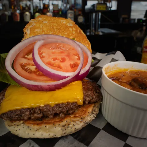 A Classic burger with American cheese, tomato and red onion, with baked beans