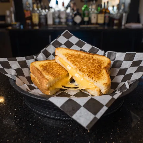 Grilled Cheese at 212 The Boiling Point: A grilled cheese sandwich on thick golden Texas toast, cut diagonally in half, melted American cheese stretch