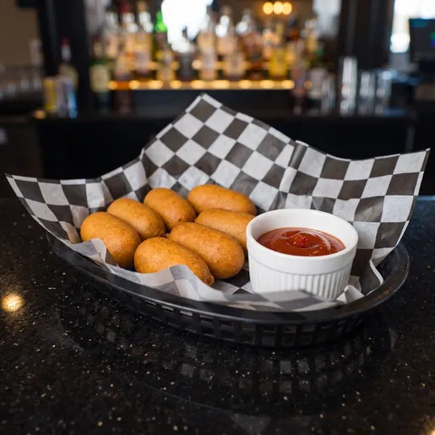 Kids Mini Corn Dogs at 212 The Boiling Point: Exactly six golden brown mini corn dogs with a small white ramekin of ketchup. This is a KIDS MENU porti