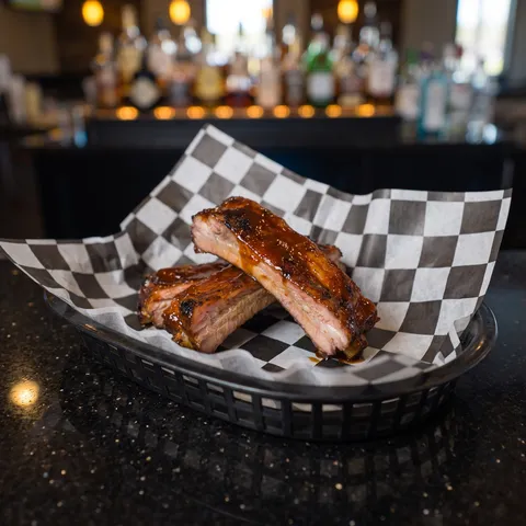 Kids Ribs at 212 The Boiling Point: Exactly three smoked BBQ pork rib bones, glazed, stacked neatly. This is a KIDS MENU portion: small, simple, neat,