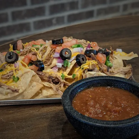 Bar nachos with house made queso, pulled pork, olives, onions and tomato, with salsa