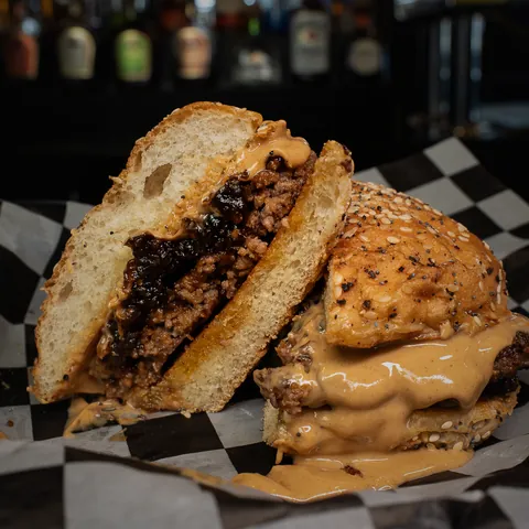The Peanut Butter Whiskey Bacon Jam burger, cut to show the bacon jam
