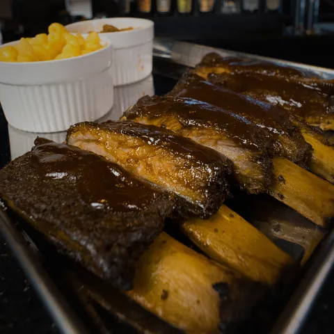 A rib platter glazed in house sauce with mac and cheese and baked beans