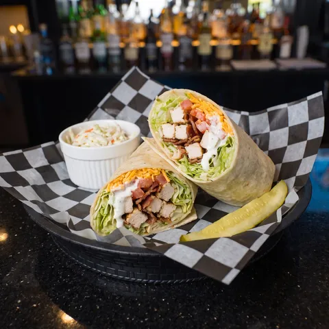 Chicken Bacon Ranch wrap cut in half showing lettuce, diced chicken, bacon, tomato, cheddar and ranch